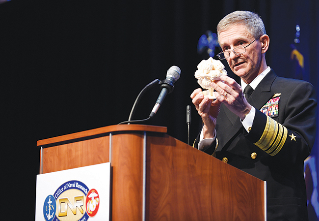 Vice Adm. Philip Cullom, deputy chief of naval operations for fleet readiness and logistics, discusses 3-D printing technology on February 5, 2015, as he shows a set of movable gears during the Naval Future Force Science and Technology Expo in Washington, DC. “It doesn’t just have to be something static,” he said of 3-D printing. “It can be gears, it can be things that move ... that’s where the power of 3-D printing potentially can take us.”