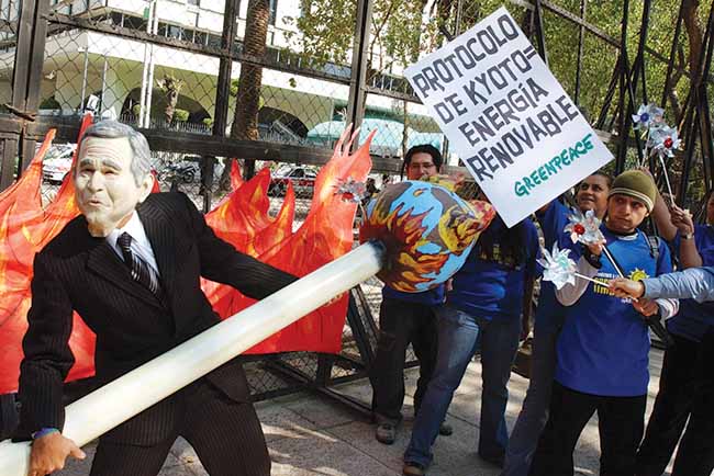 An environmental activist from Greenpeace, wearing a George W. Bush mask and carrying a sign that translates to “Kyoto Protocol=Renewable Energy,” protests February 1, 2015, outside the US Embassy in Mexico City. During the Bush administration, the United States withdrew from several international agreements, including the Kyoto Protocol on climate change and the Rome Treaty creating the International Criminal Court.