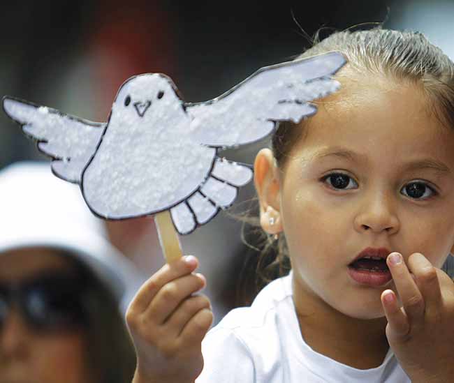 A child holds up a white paper dove November 12, 2010, in San Jose, Costa Rica, during a march dubbed The Right to Live in Peace. Costa Rica has been referred to as “a model in terms of the development of a culture of peace.”