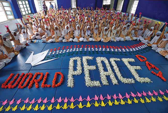 Students hold paper cranes September 21, 2017, during a ceremony in Ahmedabad, India, to mark International Peace Day. Research from the Institute of Economics and Peace has shown that a few basic factors are associated with sustaining peace.
