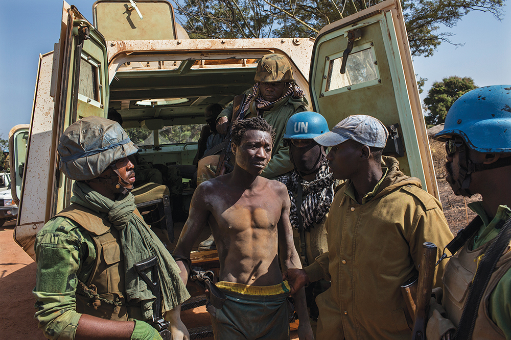 A rebel captured by members of MINUSCA and the Central African Armed Forces (FACA) stands outside of an armored vehicle in Pounambo village, Central African Republic, in January 2018. This was the first joint operation by MINUSCA and more than 50 FACA troops that arrived in late January.