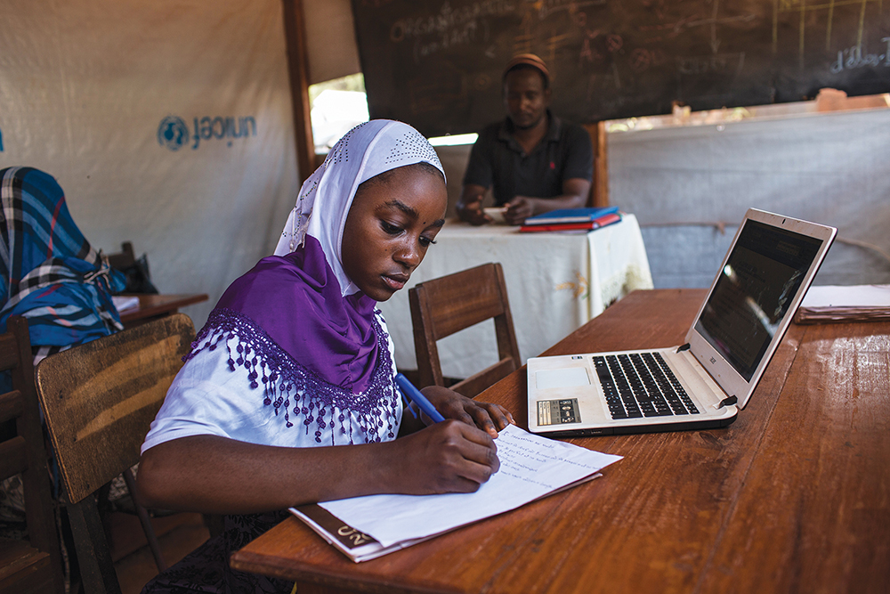 Oussna Abdraman, 17, studies at the computer lab opened by Djamaladine Mahamat Salet at the settlement for internally displaced persons on the grounds of the Bangassou Catholic mission, Central African Republic, in April 2018. Abdraman has been studying with Salet for almost three months learning Microsoft Word, Excel, Windows, general computer functions, and the Internet.