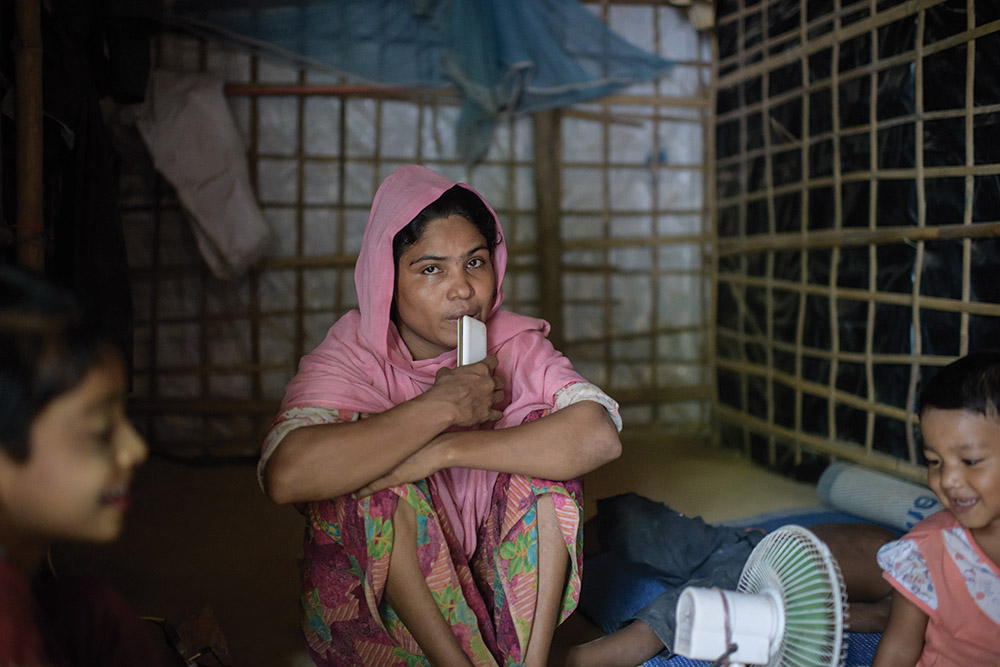 Rohingya refugee Mabia Khatun, 30, sits between her children in her tent at the Kutupalong refugee camp in Bangladesh, the day after the death of her husband, Najmul. Najmul died after months of suffering from tuberculosis and jaundice.